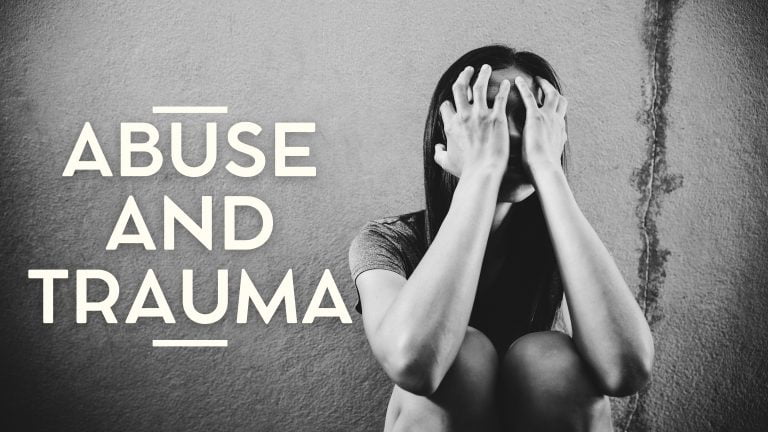 A person sitting with their head in their hands, representing themes of abuse and trauma, conveying deep emotional distress.